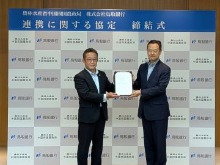 協定書を掲げる郷局長(右)と入江頭取(左)