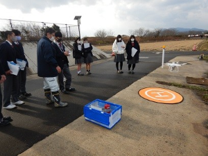 屋外で授業中の高校生