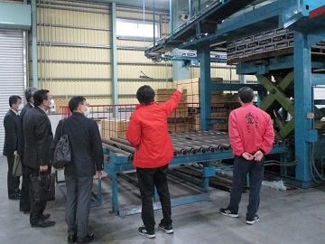 共選場長からパレタイザーの稼働状況の説明を受ける愛媛県拠点の職員