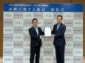 協定書を掲げる郷局長(右)と入江頭取(左)