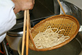 After boiling, remove the noodles from the pot with a bamboo strainer.