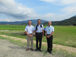 背にしているのが圃場整備後の広大な農地