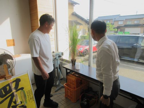 植野局長が自宅で栽培できる稲作キットについて説明を受ける様子