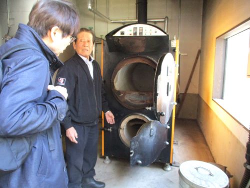 温泉加温施設の国産薪ボイラーを見学する様子