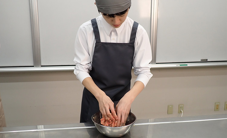 手でハンバーグのたねをこねている