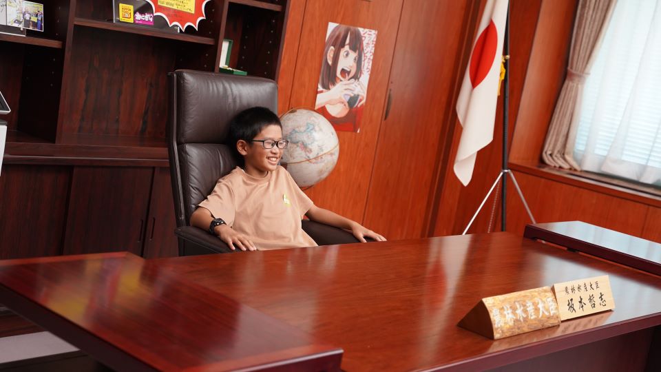 大臣室で椅子に座る子ども