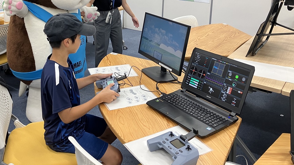 子どもがドローンシミュレーターを操作している写真