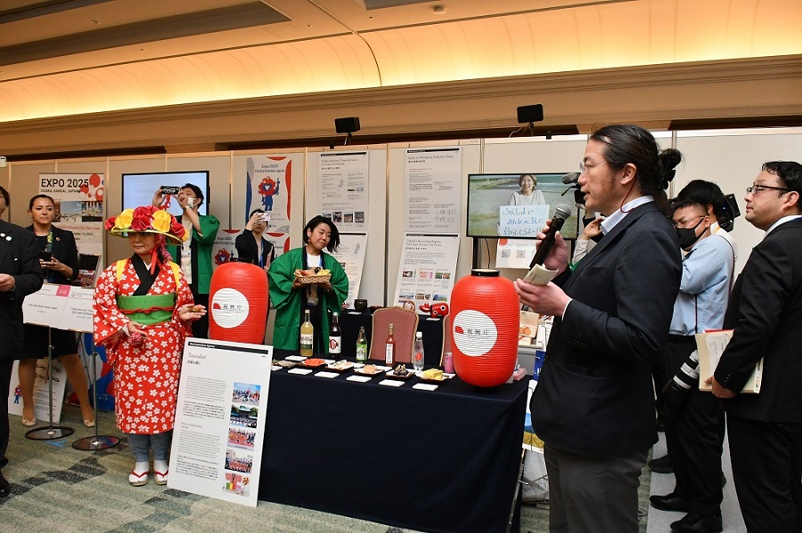 復興庁のブースの前で説明する男性