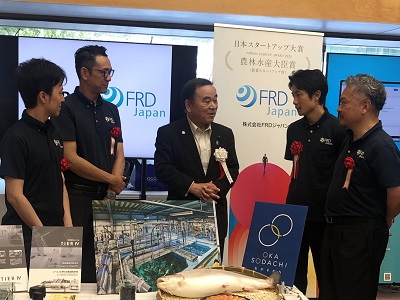 展示ブースで受賞者と意見交換を行う 坂本農林水産大臣