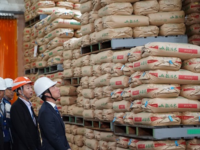 倉庫に積まれている令和3年産備蓄米について説明を受ける小泉農林水産大臣