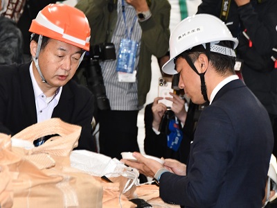 袋に入っている令和3年産備蓄米について説明を受ける小泉農林水産大臣