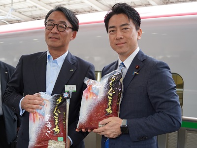 駅のホームで新幹線で輸送された米を持つ小泉農林水産大臣