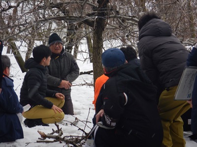 大館市中山地区梨園にて農業者から被害状況の説明を受ける鈴木農林水産大臣（左）