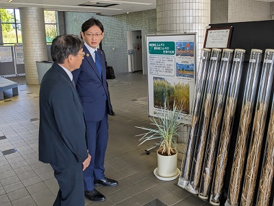 肥料が少なくても栽培可能な小麦品種の説明を受ける高橋農林水産大臣政務官