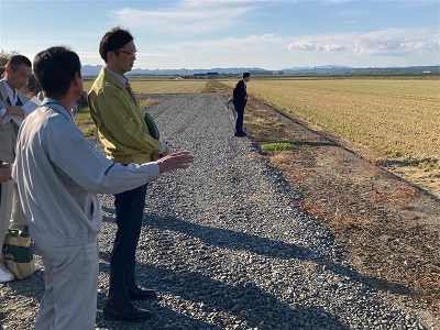 国営緊急農地再編整備事業「岩見沢北村地区」で大区画ほ場整備の概要説明を受ける高橋農林水産大臣政務官