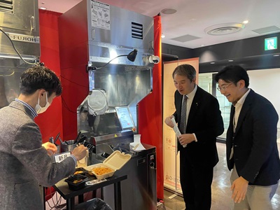 公共施設に設置されている調理ロボットについて説明を受ける広瀬農林水産大臣政務官