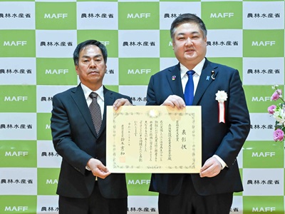 農林水産大臣賞受賞地区の代表者と写真撮影を行う山本農林水産大臣政務官（右）