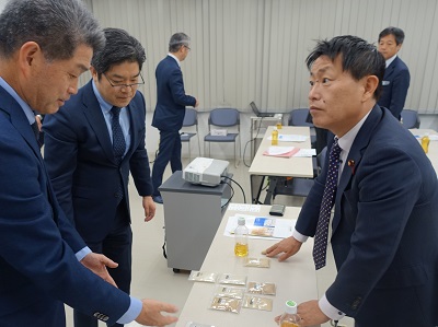栄養素を残しながら無洗米加工を行う技術について説明を受ける武村農林水産副大臣