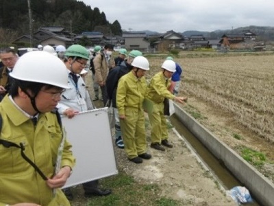 氷見市で農業用パイプラインの被災状況について説明を受ける武村農林水産副大臣（中央）
