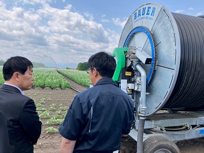 国営かんがい排水事業「芽室川西地区」内の道営モデル事業を実施したほ場にて畑地かんがいの説明を受ける武村農林水産副大臣