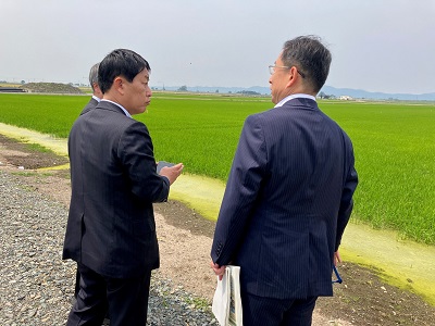 国営緊急農地再編整備事業「岩見沢北村地区」で大区画ほ場の説明を受ける武村農林水産副大臣