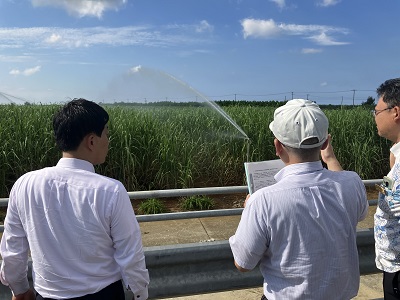 県営畑地かんがい事業「魚口地区」のさとうきび畑でスプリンクラーかんがいの説明を受ける武村農林水産副大臣
