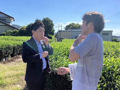 農泊施設の代表者から茶園の説明を受け、お茶の葉を試食する武村農林水産副大臣