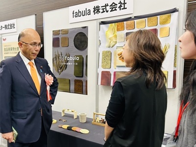 第9回食品ロス削減全国大会展示ブースで説明を受ける根本農林水産副大臣