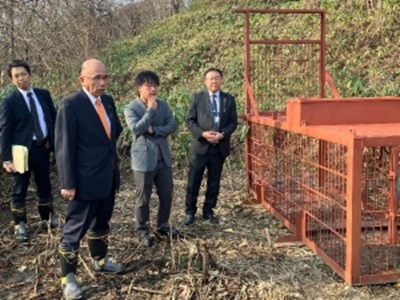 三笠市内に設置されたヒグマ用箱わなを視察する根本農林水産副大臣（左から2人目）