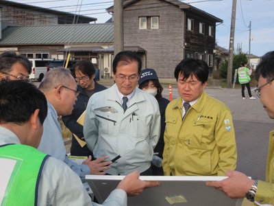 直轄災害復旧事業 氷見地区にて被害、復旧状況の説明を受ける山下農林水産副大臣（右端）