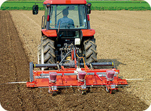 大豆は弱アルカリ性の土壌でよく育つ。7月中旬、トラクター後部に播種機を取り付けて種まきをする。