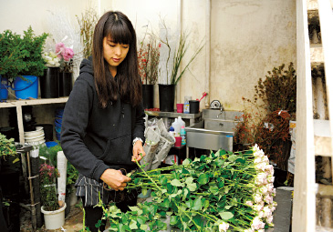 仕入れた花をきれいに整える。バラはナイフで少しずつトゲを除去。道具は事前に消毒済み。