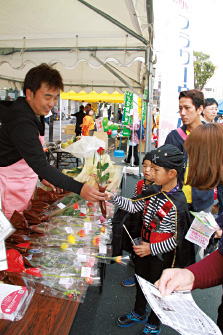 とよはしフラワーウォークの催しでバラを手渡す山口さん。