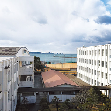 昨年度、創立100周年を迎えた神島高校。グラウンドの先には跡之浦（あとのうら）湾が広がっている。