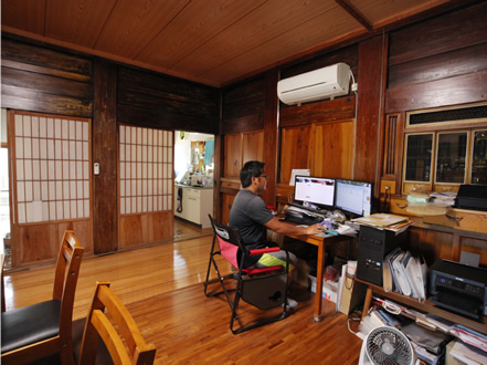 築100年を超える古民家を事務所兼住居としている。パソコンで事務を行う須崎さんは、銭本さんの研究者時代の後輩。