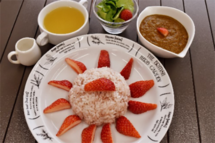 いちごと一緒に炊いたピンク色のご飯に、さらにいちごをトッピングしたカレーライス。カレールウにいちごソースを好みで加えることで、まろやかな味に調節できる。
