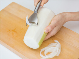 大根はピーラーで皮ごと15センチメートルくらいの長さで薄切りに。万能ねぎは4センチメートルくらいに切る。