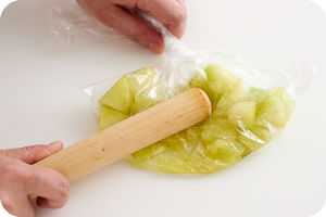 写真:切ったメロンをポリ袋に入れ、麺棒でたたく