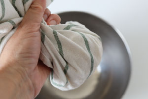 写真：茹でたスパゲッティを布巾で包んで水気を絞る