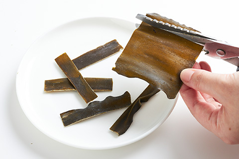 写真：はさみでコンブを切る