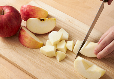 写真：りんごの皮を剥いて芯を取り、いちょう切りにする
