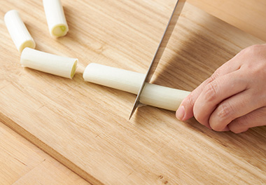 写真：仙台曲がりねぎをぶつ切りにする