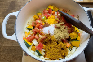 写真:トマトと塩、スパイス類を加えて炒め、水を加えて中火で煮込む