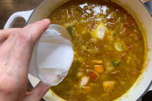 写真:野菜が柔らかくなったら水で溶かした米粉を加えてとろみを付ける