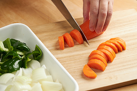写真：にんじん、たまねぎ、ピーマンを切る