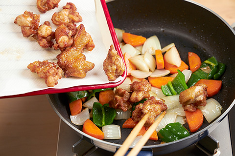 写真：揚げた肉、野菜を混ぜ炒める