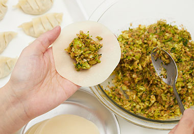 写真：よく混ぜ餃子の皮で包む