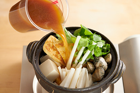 写真：土鍋に材料を入れ、火にかける