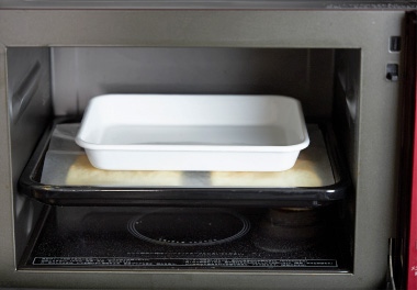 写真：200度に熱したオーブンで10分焼き、クッキングペーパー、天板を重石にしてさらに10分焼く