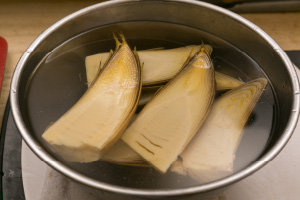 写真:水にさらしボールの中でさっと洗い、流水でたけのこに付着している米ぬかをきれいに洗い流す